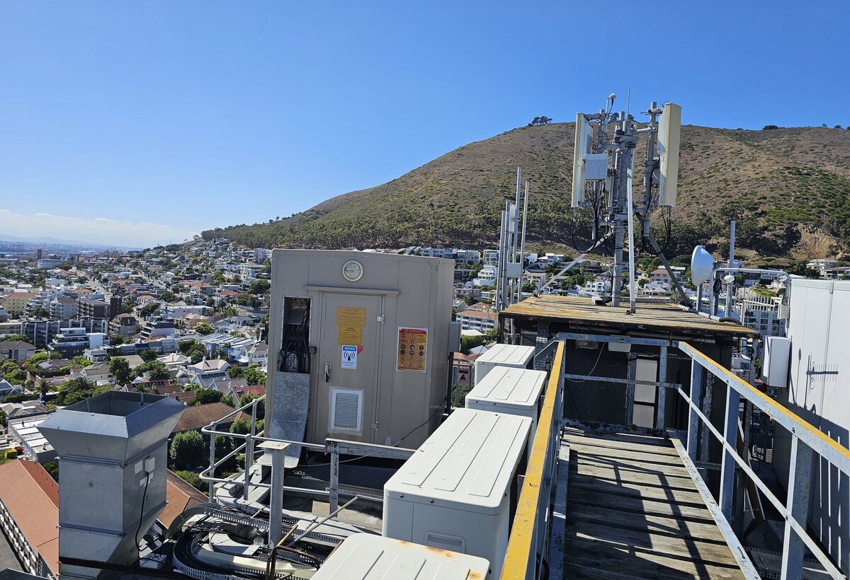Rooftop telecommunications site with antennas, microwave dishes and equipment cabinets